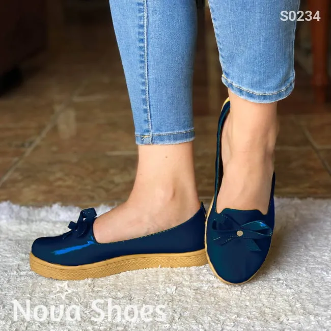 Zapatos bajos hechos en charol, decorados con un chongo